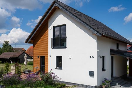 Modernes Einfamilienhaus in Lichtenau mit Holz-Putz-Fassade, schwarzem Satteldach und Hausnummer 4b – geplant und realisiert von Wiese und Heckmann